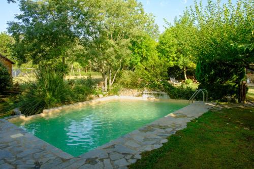 贝萨卢Alojamiento con encanto en Cataluña的一座树木繁茂的庭院内的游泳池