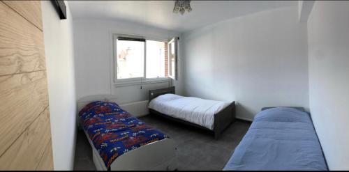 TemplemarsBel appartement cosy très calme avec parking privé的一间小卧室,配有两张床和窗户