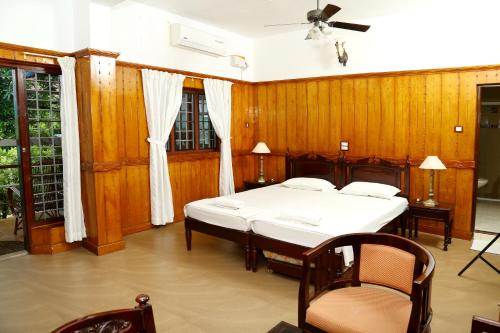 Fort KochiWalton's Homestay, Fort Cochin的一间卧室设有两张床和木墙