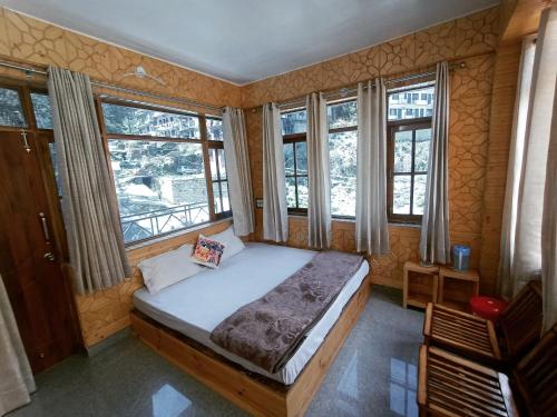 西姆拉The MoonLight Stay - Shimla的一间设有床铺的卧室,位于带窗户的房间内