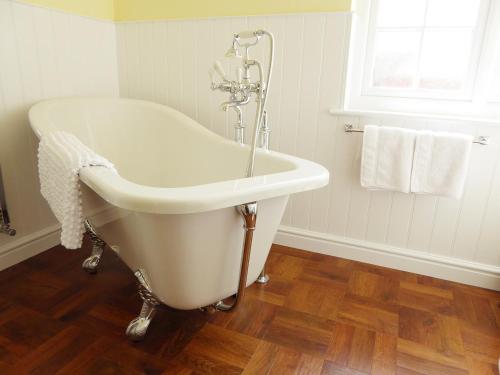 韦茅斯Pump Cottage的带窗户的浴室内的白色浴缸