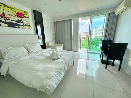 芭堤雅市中心City Center Residence & Yahaha的卧室配有白色的床、书桌和椅子