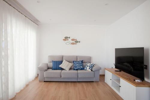 奥利瓦Acogedor apartamento junto al mar的带沙发和平面电视的客厅