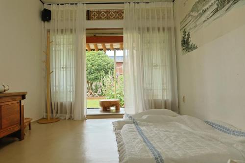 顺天市Daoljae Hanok Pension的一间卧室设有一张床和一个大窗户