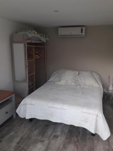 勒卡内logement individuel的卧室配有白色的床和梳妆台。