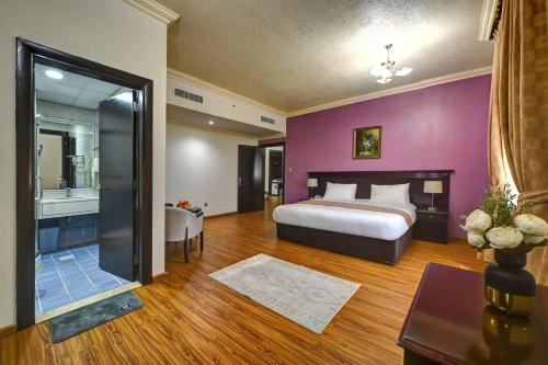 沙迦阿尔布斯坦酒店的一间带大床的卧室和一间浴室