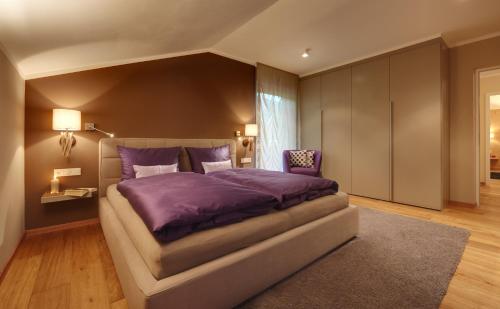 维拉巴萨Crioli Dolomiti Lodge的一间卧室配有一张大床和紫色棉被