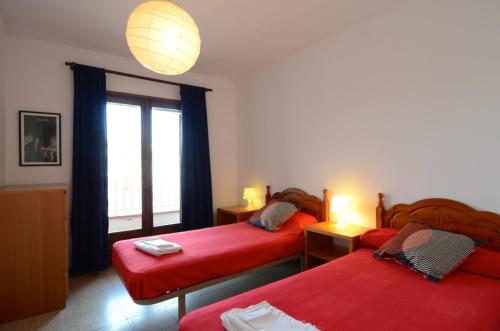 莱斯卡拉Apartamentos Els Pescadors的一间卧室设有两张床和窗户。