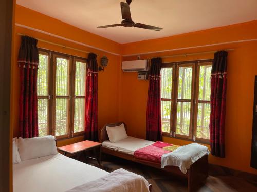 索拉哈Tara guesthouse - Sauraha,Chitwan的一间卧室配有两张床和吊扇