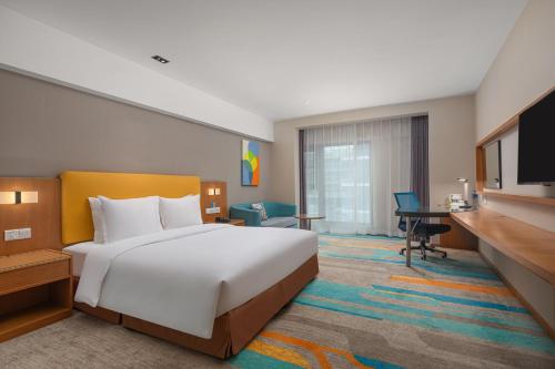 西安西安南曲江智选假日酒店的酒店客房设有一张大床和一张书桌。