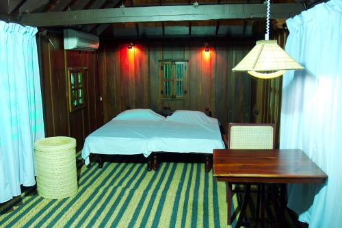 阿勒皮Elephant Courtyard- A Heritage Homestay的一间卧室配有一张床、一张桌子和一张桌子