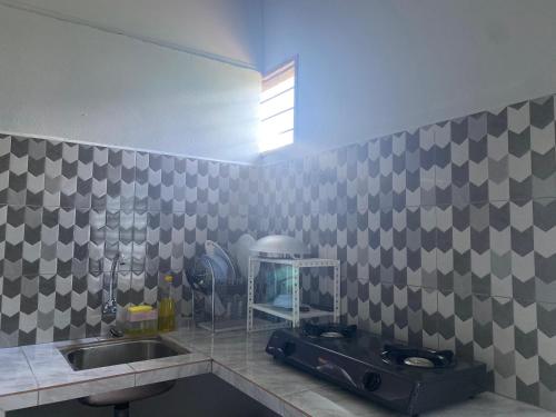 亚娄RUMAH INAP 09的厨房配有水槽和带镜子的台面
