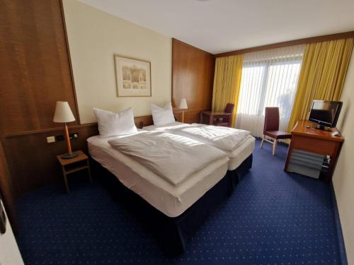 圣奥古斯丁Hotel Regina的酒店客房设有一张大床和一台电视。