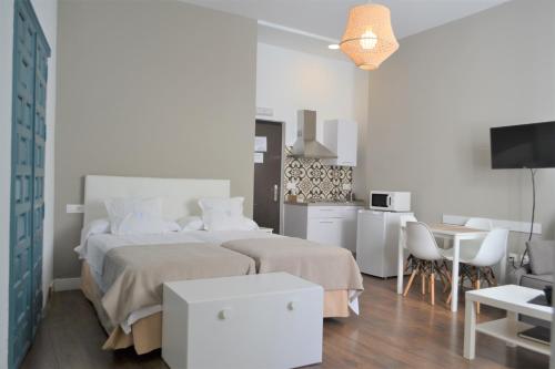 科尔多瓦SunShine Barroso Centro的一间白色卧室,配有两张床和厨房