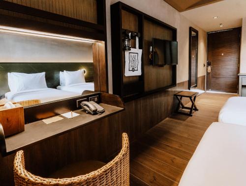 爱妮岛The Funny Lion - El Nido的酒店客房配有一张床、一张书桌和一部电话