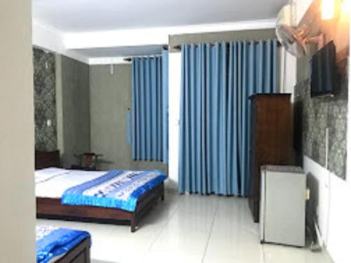 胡志明市Bluesky Tan Son Nhat Golf Center Hotel的一间卧室配有一张床和蓝色窗帘