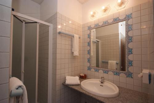 马西亚娜马里纳Residence Il Gabbiano Azzurro的一间带水槽和镜子的浴室