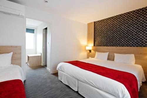 瓦讷瓦纳中心基里雅德酒店的酒店客房,配有两张带红色床单的床