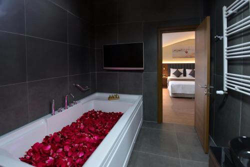 ArnavutköyİSTPORT GARDEN HOTELS的一间设有装满红玫瑰的浴缸的浴室