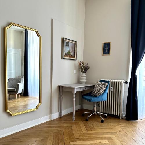 尚贝里Appartement d exception 100m2 avec Parking - Centre historique的一张桌子和一把椅子,镜子在房间里