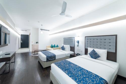 海得拉巴Hotel Deccan Serai Grande, Gachibowli, Hyderabad的酒店客房配有两张床和一张书桌
