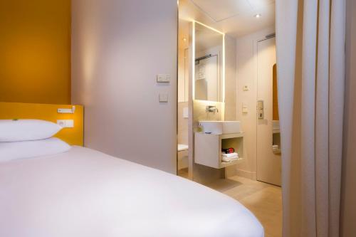 巴黎安德里亚酒店的一间带白色床的卧室和一间浴室