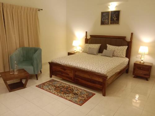 班加罗尔Luxre Homes - Villa in Koramangala的一间卧室配有一张床和一张蓝色椅子