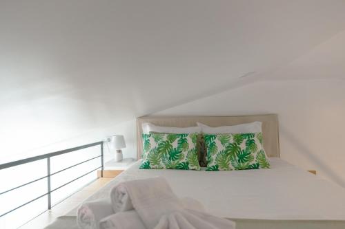 奥比多斯Antiga adega的白色卧室配有带绿色枕头的床