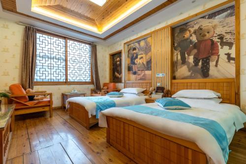 峨眉山Mount Emei Teddy Bear Hotel的一间卧室设有两张床,墙上挂着一幅画