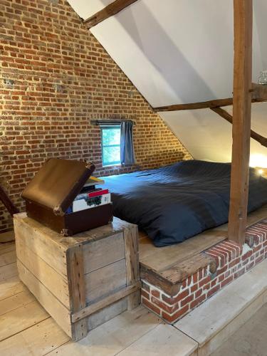 迪斯特爱因斯坦艺术乡村民宿的一间卧室设有一张床和砖墙