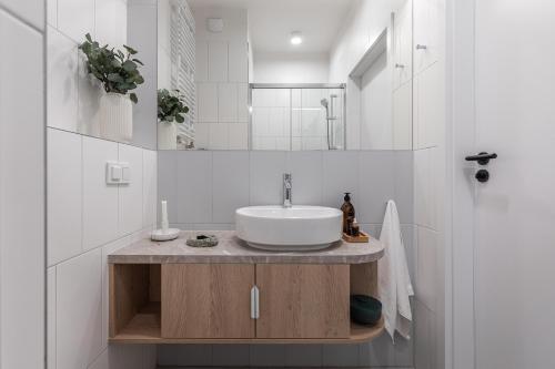 华沙Noli Mokotow的白色的浴室设有水槽和镜子