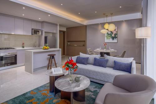 内罗毕Pan Pacific Serviced Suites Nairobi的客厅以及带沙发和桌子的厨房。