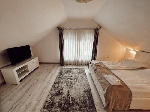 Vicovu de JosCazare Vicoveancaa的一间卧室配有一张大床和电视
