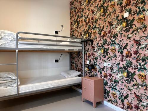 里尔Auberge de Jeunesse HI Lille的一间卧室配有双层床和花卉壁纸