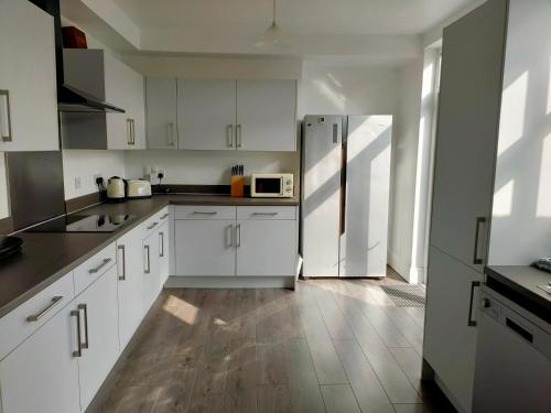 唐克斯特Wentworth Road Accomodation的厨房配有白色橱柜和冰箱。