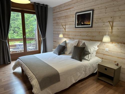 奥尔贝Coté Forêt的一间卧室设有一张带木墙的大床