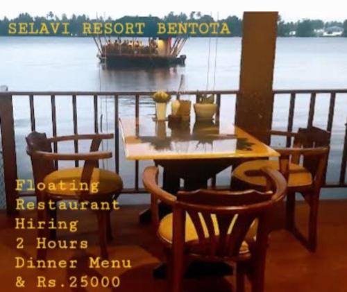 本托塔Selavi Resort Bentota的一张木桌和椅子,船上有一条船