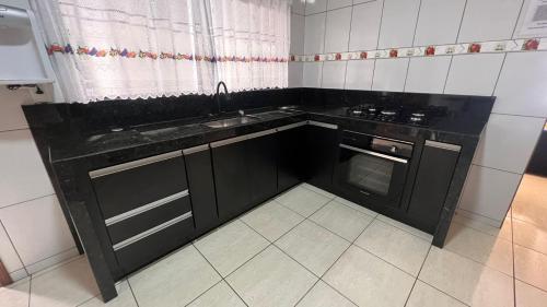 塞拉内格拉RANCHO KWILL的厨房配有黑色橱柜和水槽