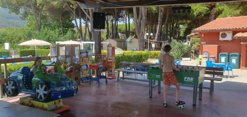 阿梅利亚Luxe Mobilehome with dishwasher and airconditioning included fits 4 adults and 1 child, Ameglia, Ligurie, Cinqueterre, North Italy, Beach, Pool, Glamping的两个孩子在公园的游乐场玩耍