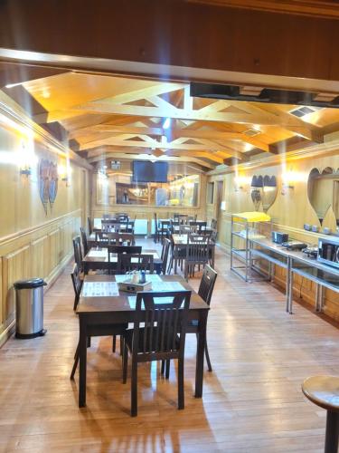 蓬塔阿雷纳斯Hostal Balmaceda的一间带木桌椅的餐厅和一间厨房