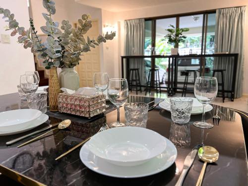 Bang KapiSukhumvit 31 Sweet Home 7 beds - up to 12 guests的餐桌,上面有盘子和玻璃杯