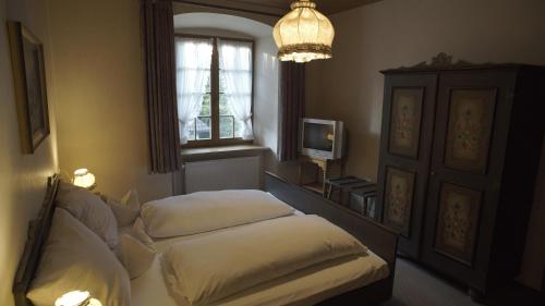 瓦尔茨胡特田根Fährhaus Hotel的一间卧室设有两张床、一个窗户和一个吊灯。