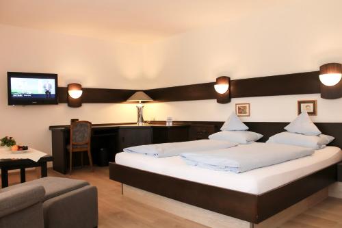 施马伦贝格Hotel Stockhausen GbR的一间卧室配有两张床、一张沙发和一台电视