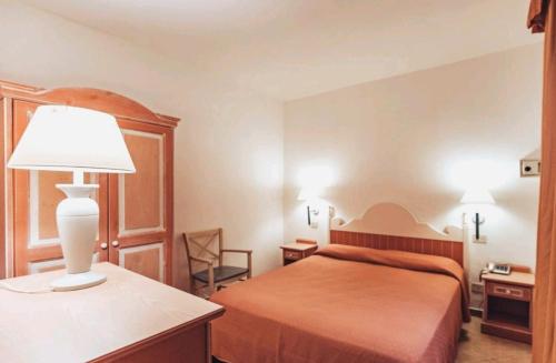 罗通多港Residence Hotel Nuraghe的酒店客房,配有床和灯