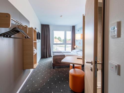 奥格斯堡B&B Hotel Augsburg-Nord的配有一张床和一张书桌的酒店客房