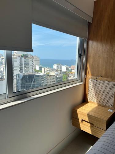 里约热内卢Rio Flat Leblon的一间卧室设有窗户,享有城市美景