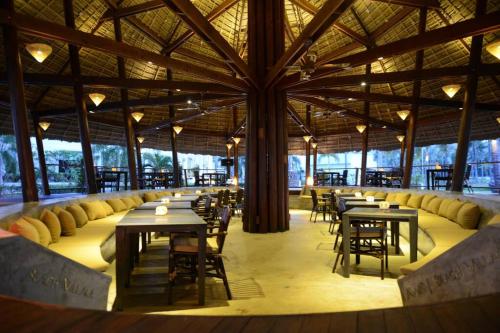 三百岭@beach village的一间带桌椅和大型天花板的餐厅
