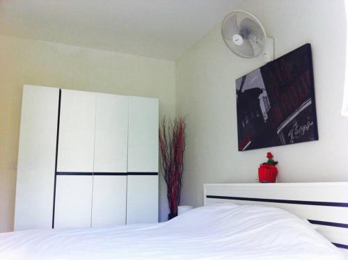 三百岭@beach village的卧室配有白色的床和白色橱柜