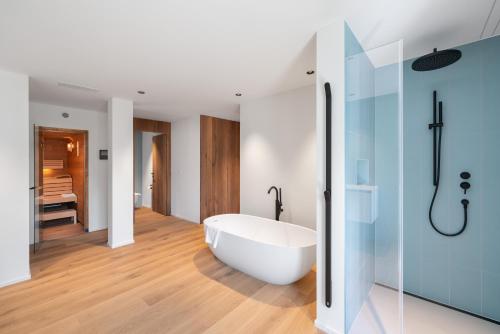 英格堡Swiss Hotel Apartments - Engelberg的浴室配有白色浴缸和淋浴。
