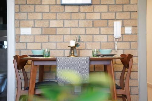 科威特Nakheel Residence Sabah Alsalem by House living的餐桌、椅子和砖墙